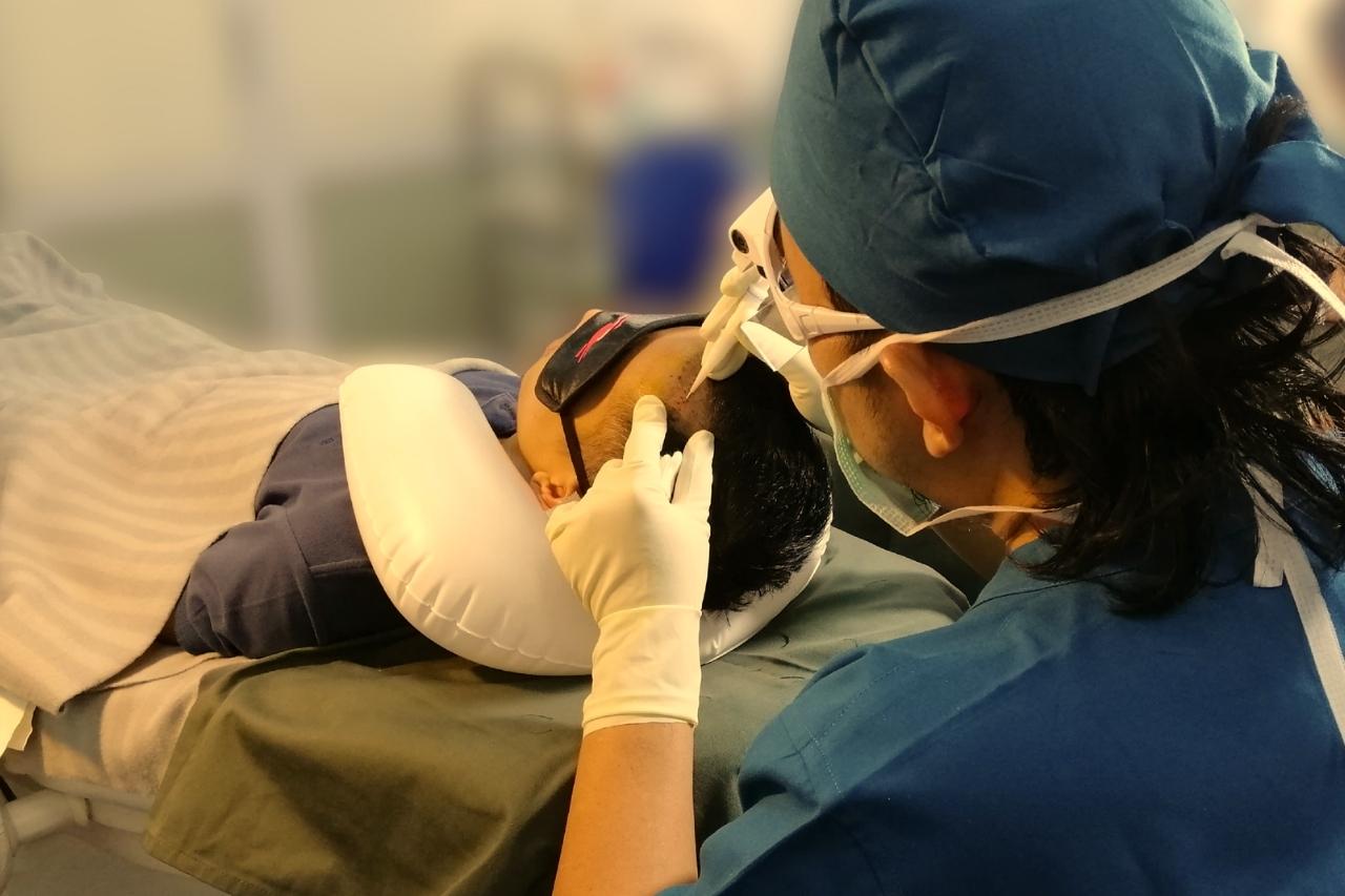 Dr Ruz performing FUE hair transplant procedure on patient at clinic in Malaysia